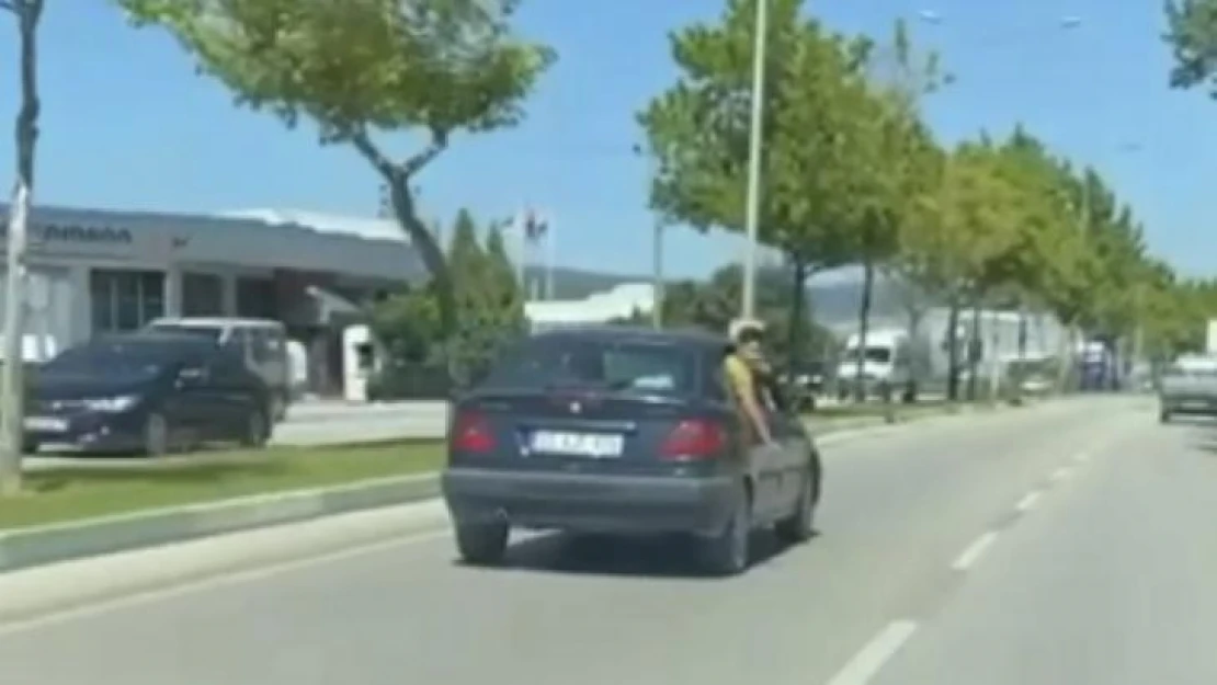 Canını hiçe sayan çocuk, otomobilin camından sarktı