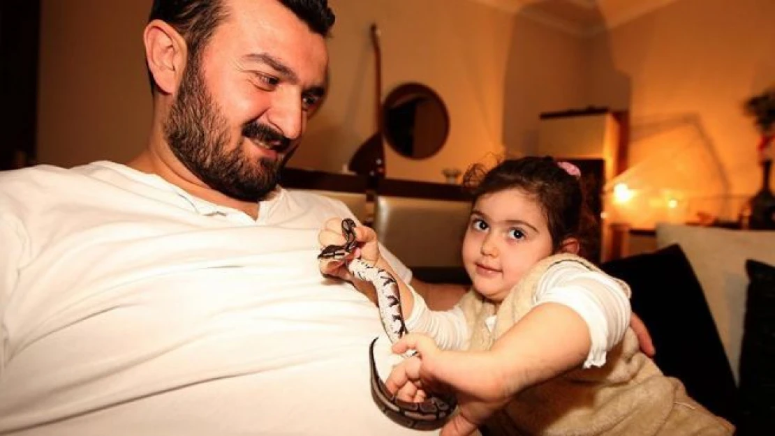 Küçük kızının isteğiyle evinde piton besliyor