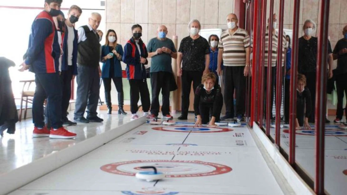 Yaşlılar ve gençlerin renkli curling müsabakası