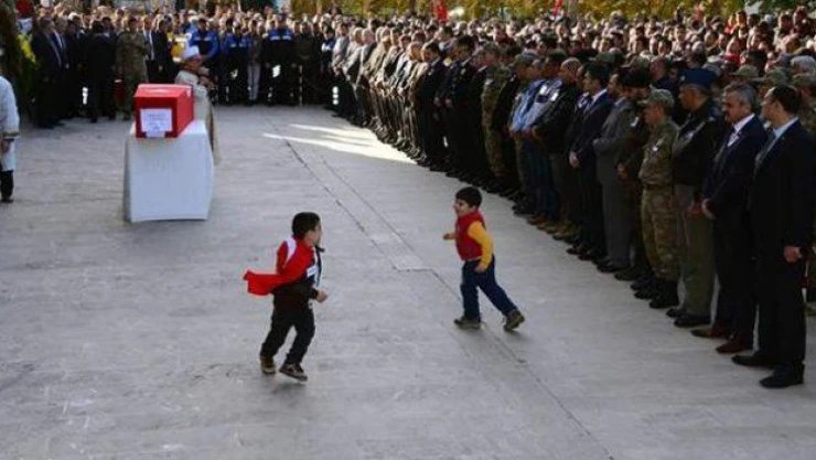 Babasının bayrağa sarılı tabutunu öpen küçük Melih... Ölüler uyuyor değil mi?